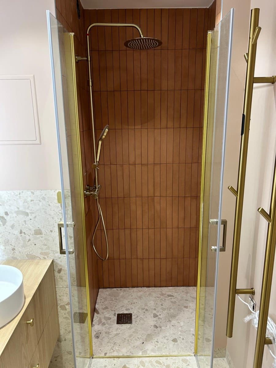 Douche à l'italienne carrelage terracotta et colonne de douche dorée — FPC Lyon